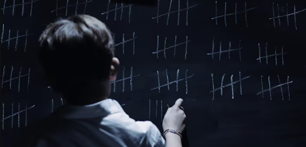 Picture of a kid drawing on a blackboard